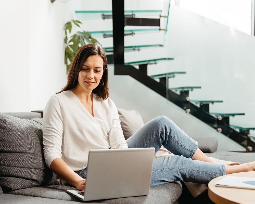 Kobieta siedząca na kanapie z laptopem