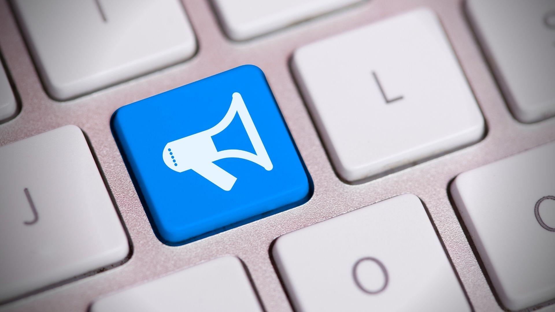 Zdjęcie ukazuje część klawiatury komputerowej, ale zamiast literki K na przycisku jest klawisz w innym kolorze z ikonką megafonu.